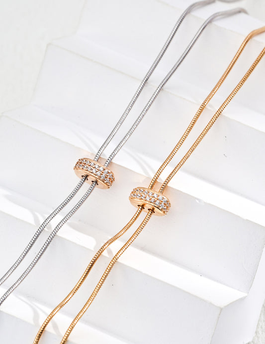 Handcrafted S925 sterling silver necklace featuring sparkling zirconia accents against a vintage gold or vintage gold with platinum finish. The adjustable 65cm chain allows for versatile styling, perfect for achieving a shorter, layered look or a dramatic, elongated style. 