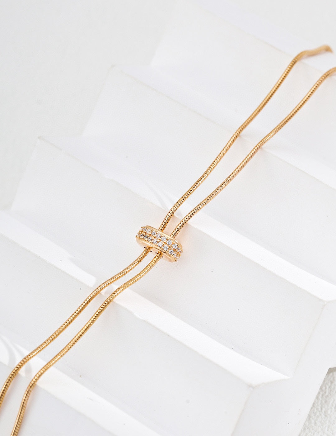 Handcrafted S925 sterling silver necklace featuring sparkling zirconia accents against a vintage gold or vintage gold with platinum finish. The adjustable 65cm chain allows for versatile styling, perfect for achieving a shorter, layered look or a dramatic, elongated style. 