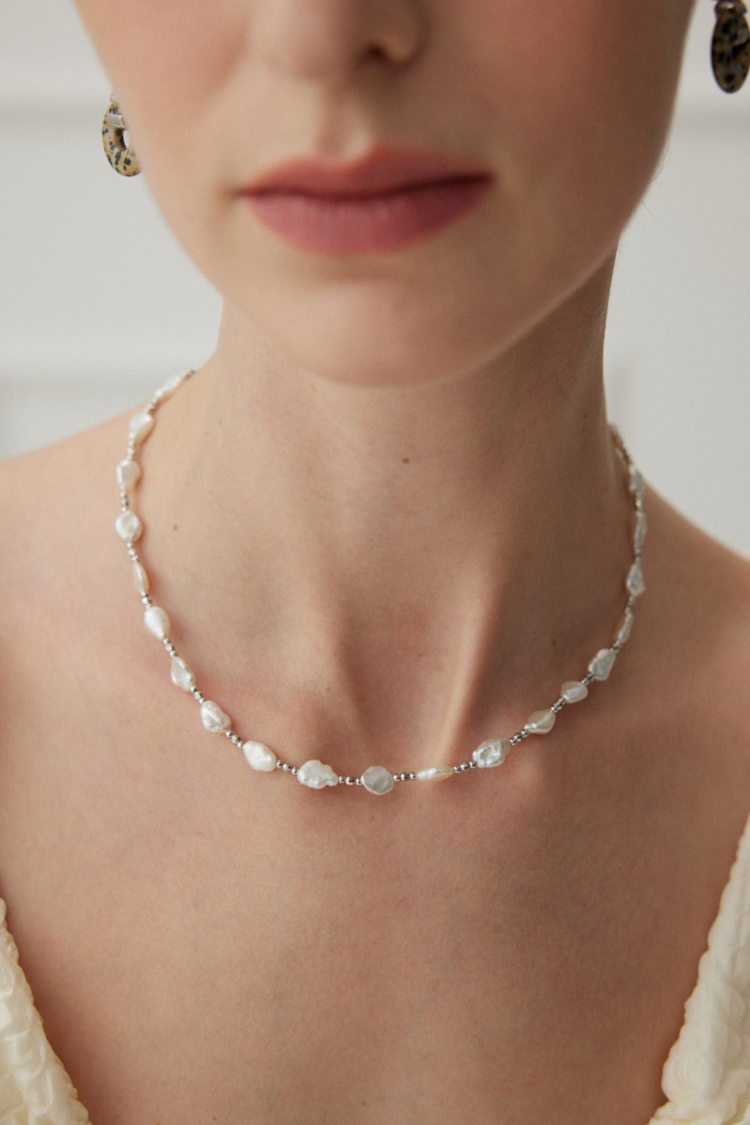 Stunning baroque pearl necklace crafted from high-quality S925 silver and finished in radiant white gold. This elegant piece features a chain length of 41cm with a 5cm extension chain, silver bead widths of 1.5-2mm, and baroque pearl widths of 6-7mm. Inspired by the elegance of Baroque art, this necklace embodies tranquility and luxury, making it a timeless addition to any jewelry collection suitable for all occasions.