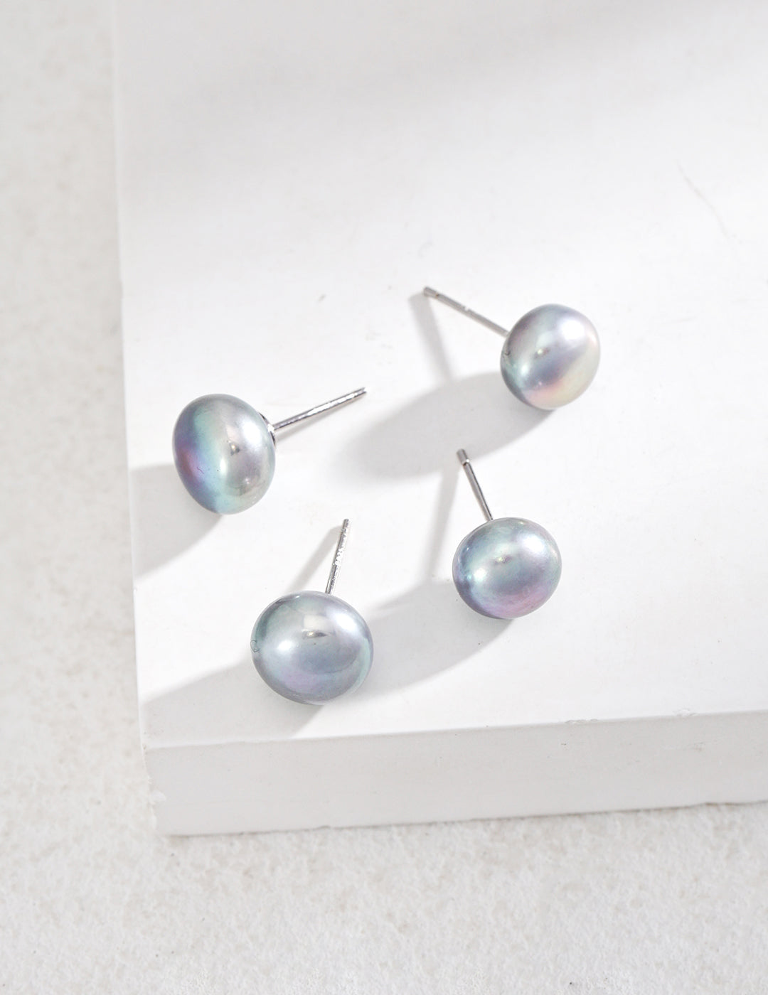 Minimalist earrings made from 925 silver featuring natural pearls with a width of approximately 1.6cm. These white gold earrings showcase a delicate pairing of pearls, radiating a soft, luminous glow, perfect for any occasion.