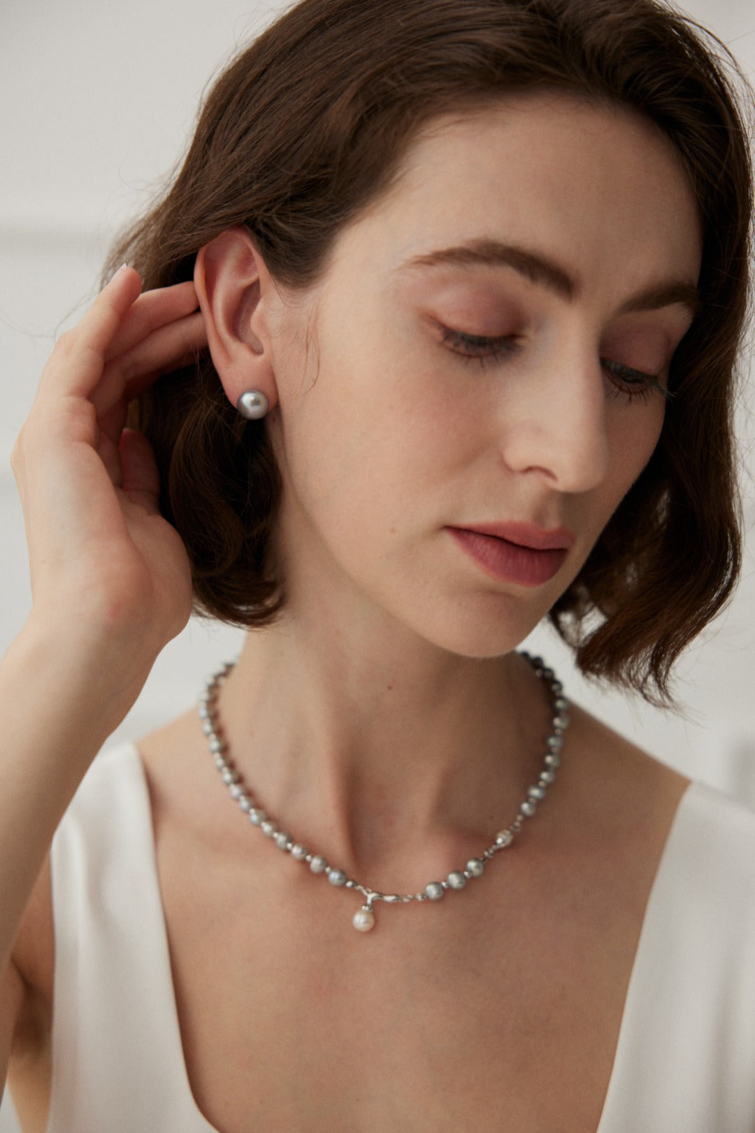 Minimalist earrings made from 925 silver featuring natural pearls with a width of approximately 1.6cm. These white gold earrings showcase a delicate pairing of pearls, radiating a soft, luminous glow, perfect for any occasion.