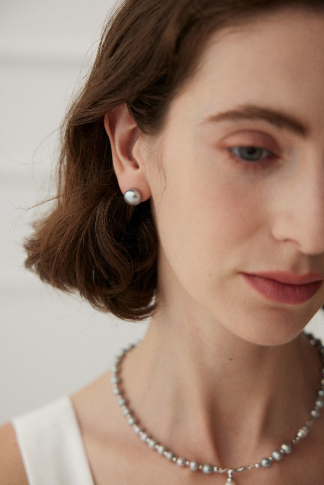 Minimalist earrings made from 925 silver featuring natural pearls with a width of approximately 1.6cm. These white gold earrings showcase a delicate pairing of pearls, radiating a soft, luminous glow, perfect for any occasion.