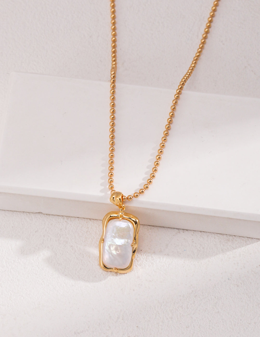 Natural rectangle baroque pearl necklace crafted from high-quality 925 silver with a vintage gold finish. This necklace features a unique rectangular baroque pearl pendant, measuring approximately 2cm high and 1cm wide, adding a modern twist to classic elegance. With a chain length of 39cm plus a 6cm extension, this necklace is perfect for everyday wear or special occasions, making it an ideal accessory for any jewelry collection.