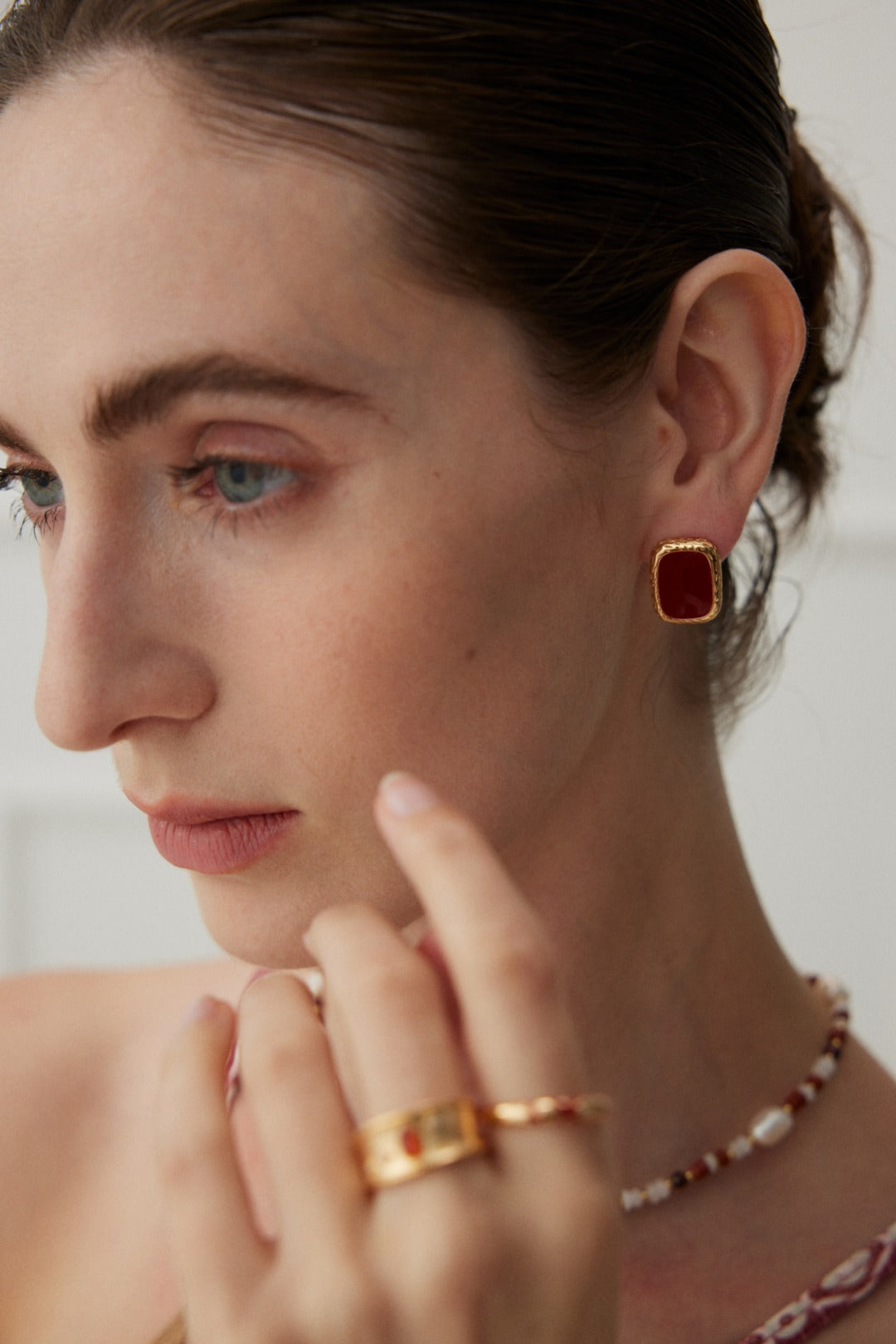 Sterling silver earrings with a vibrant red drop glaze, finished in vintage gold. Measuring approximately 1.8cm in height and 1.3cm in width, these modern earrings add a lively pop of color and flair to any outfit.