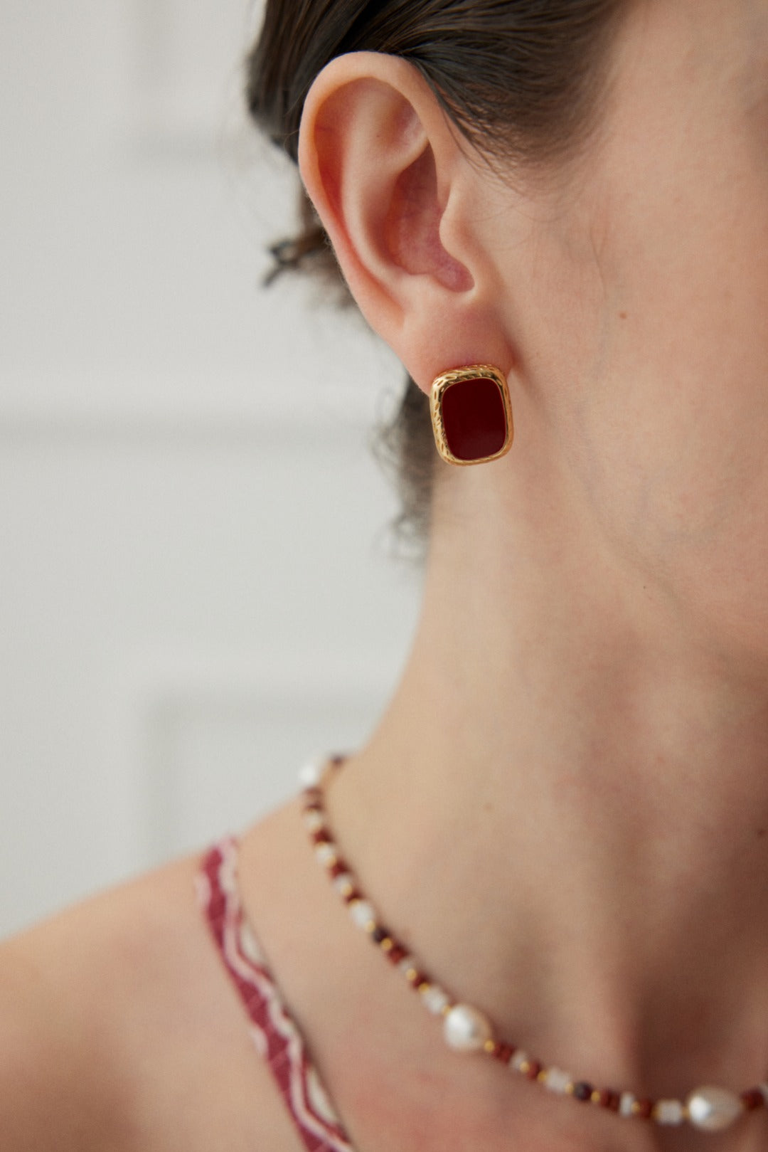 Sterling silver earrings with a vibrant red drop glaze, finished in vintage gold. Measuring approximately 1.8cm in height and 1.3cm in width, these modern earrings add a lively pop of color and flair to any outfit.