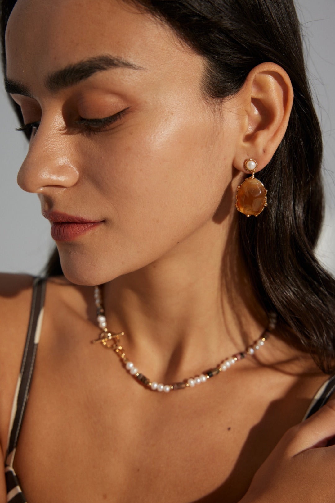 Elegant earrings crafted from premium 925 sterling silver, featuring lustrous 5mm natural pearls and eye-catching resin stones, finished in a vintage gold hue. Measuring 3.6cm in height and 2cm in width, these earrings embody the charm of vintage jewelry, making them perfect for formal events or adding a touch of flair to everyday outfits.